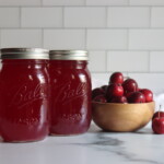 Crabapple Juice in jars on a counter next to red crabapples.