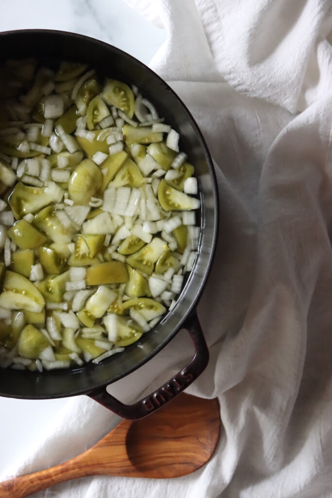 Green tomatoes and onions in a pot with vinegar to cook into chow chow.