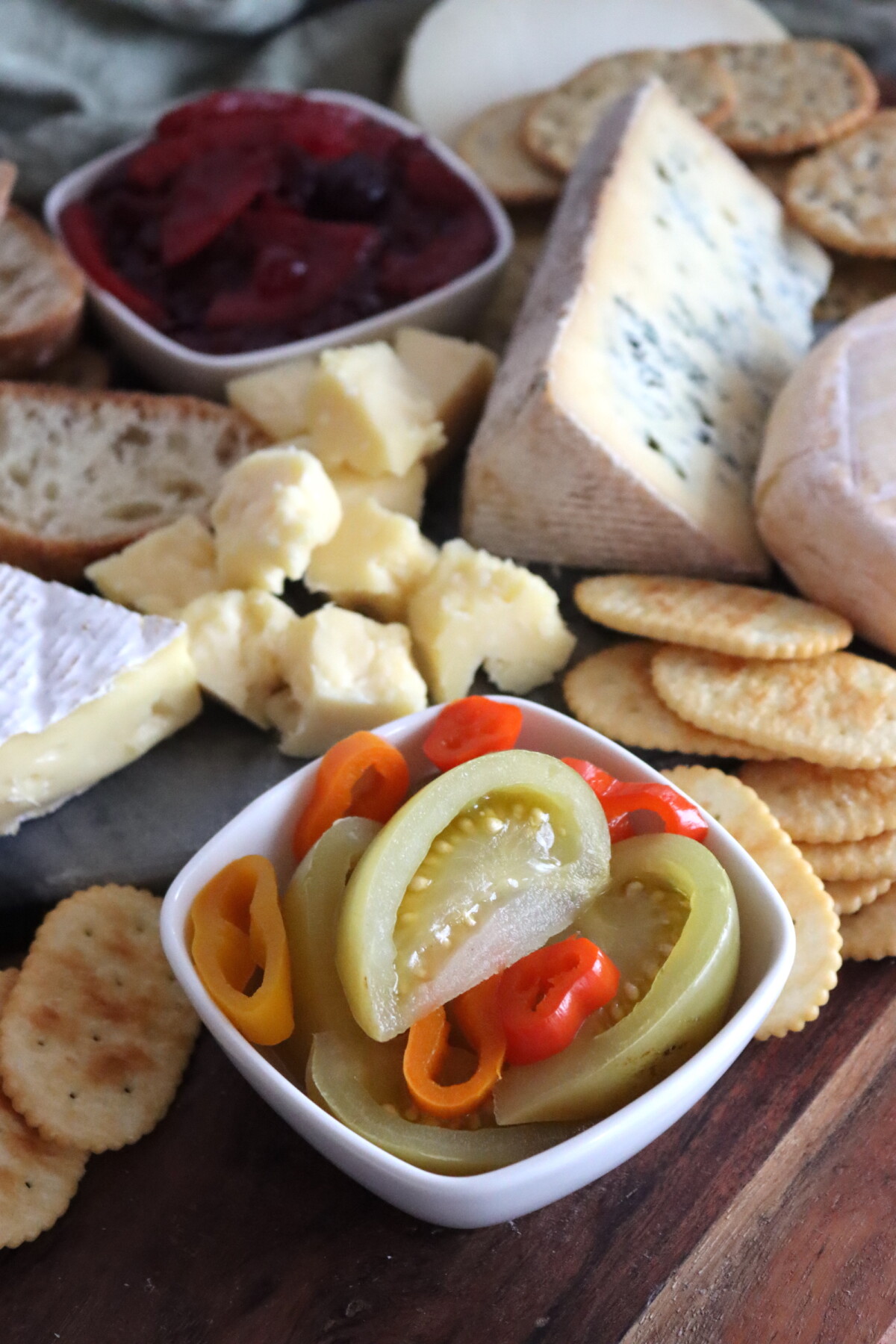 Spicy pickled green tomatoes on a cheese board.