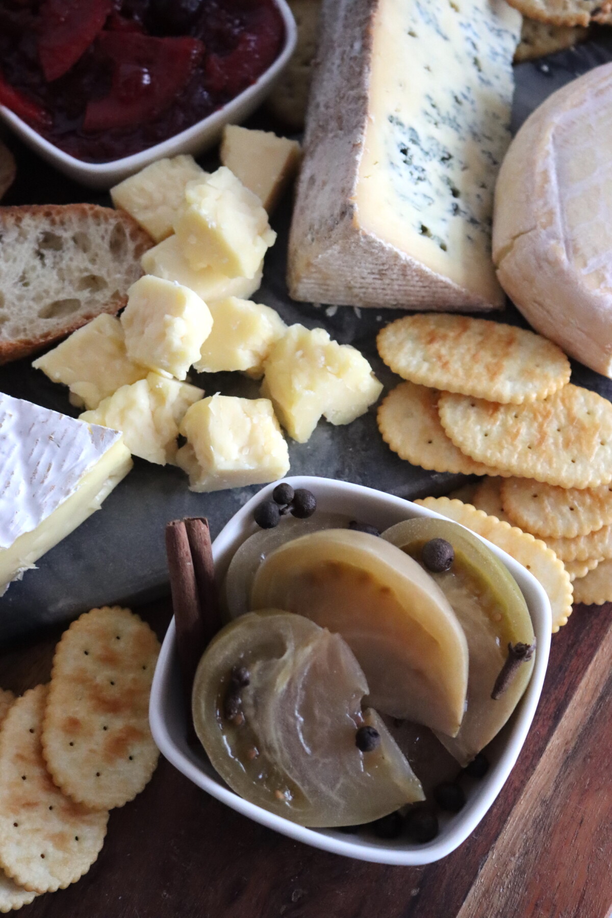 Closeup of Sweet Pickled Green Tomatoes served on a cheese board.