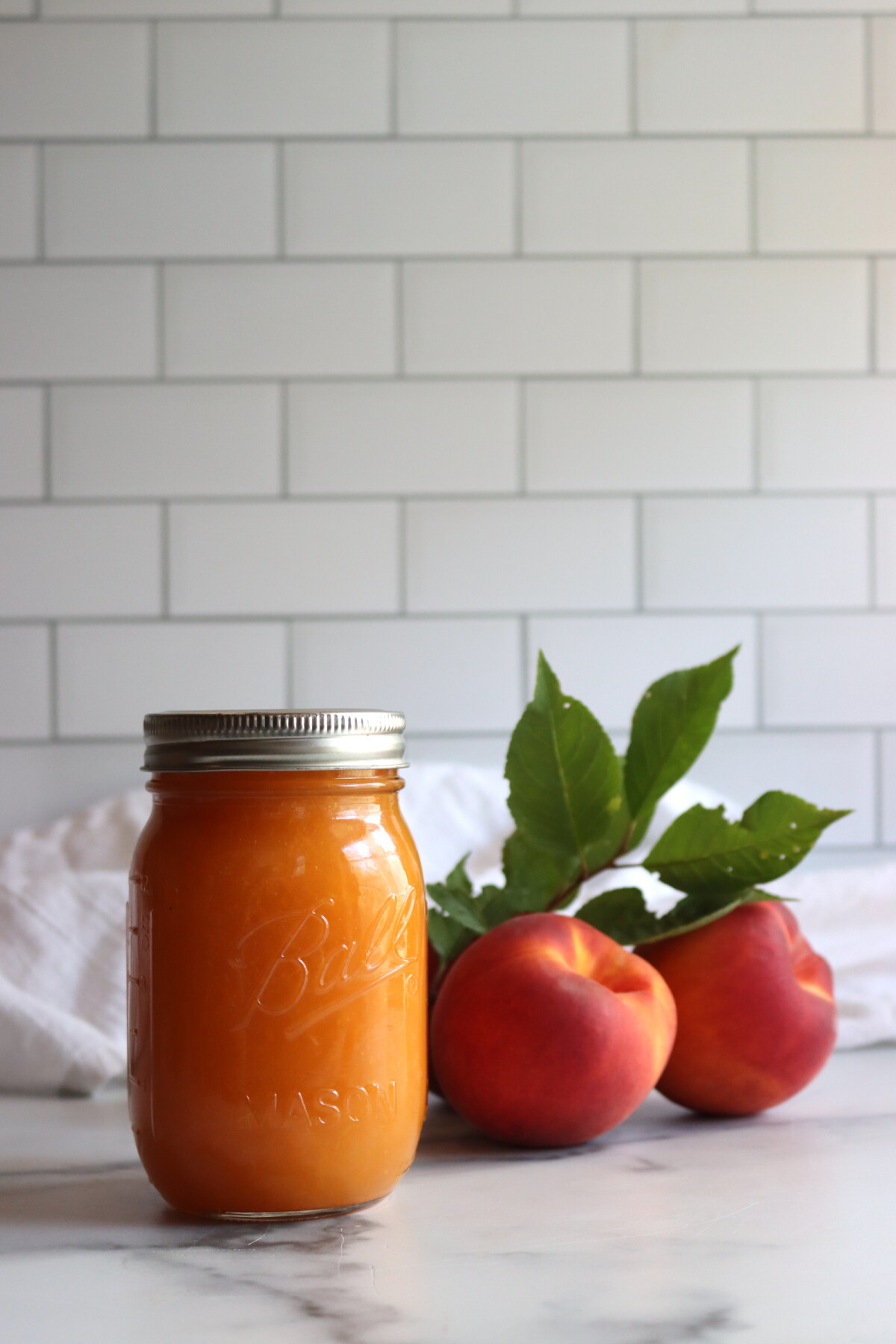 Finished peach applesauce in a jar with a spoon