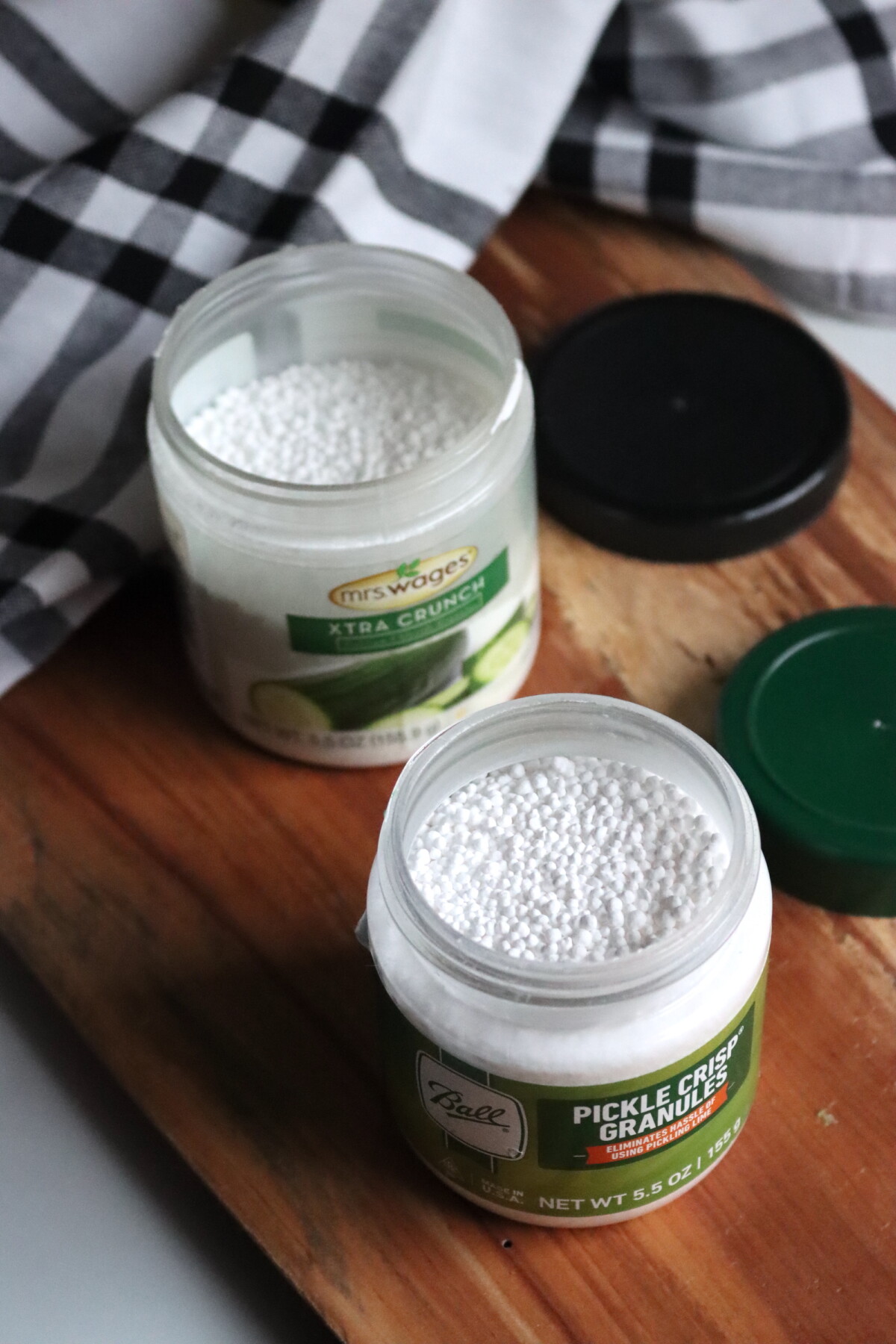 An open jar of Mrs. Wages Xtra Crunch and another of Ball Canning's Pickle Crisp Granules.