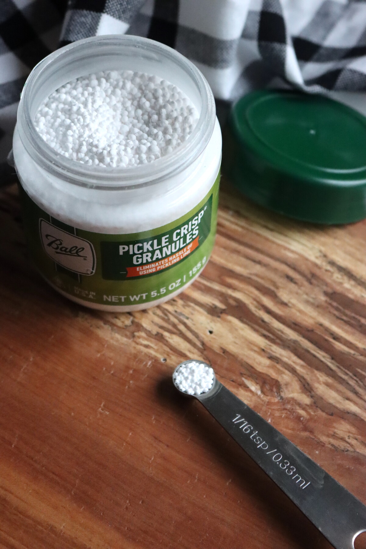 Pickle Crisp Amount in a 1/16th tsp measuring spoon on a cutting board.