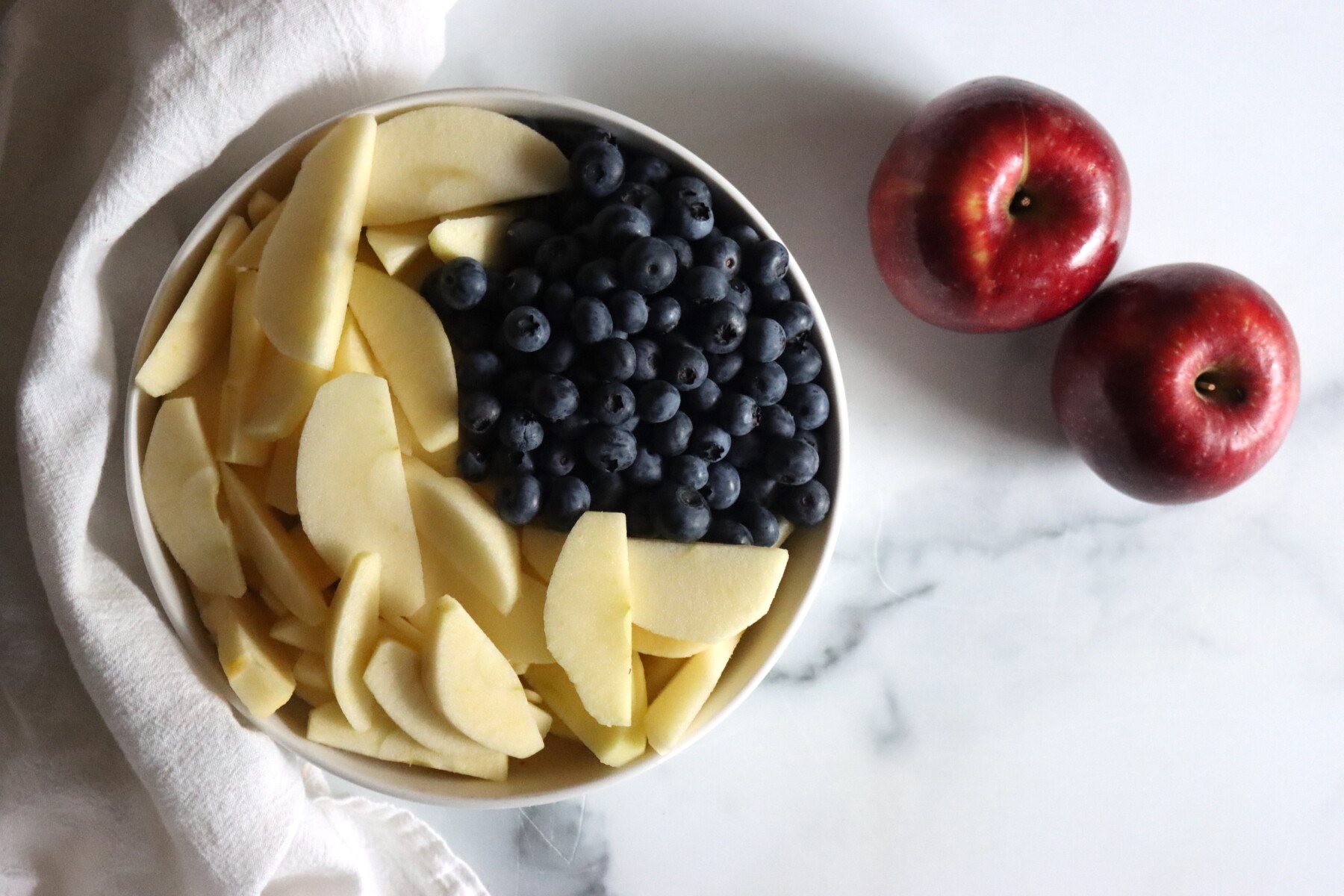 Apples and blueberries prepared for making blueberry applesauce