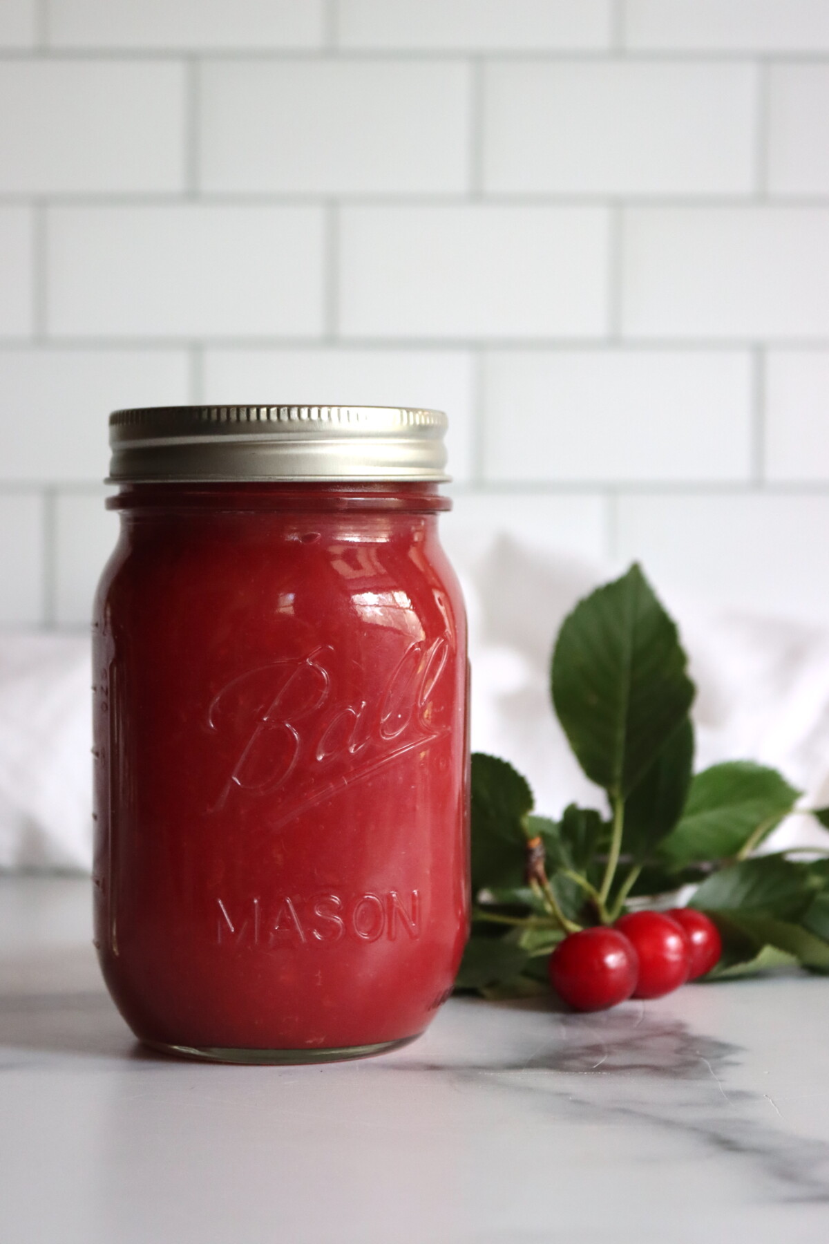 Cherry applesauce in a jar with a spoon