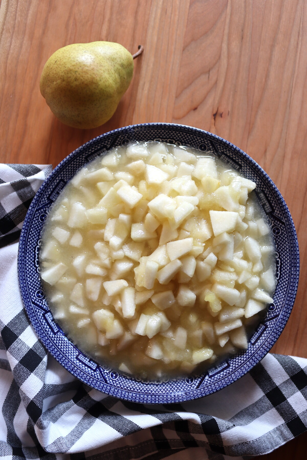 Bowl of diced pears for pear honey next to a whole pear