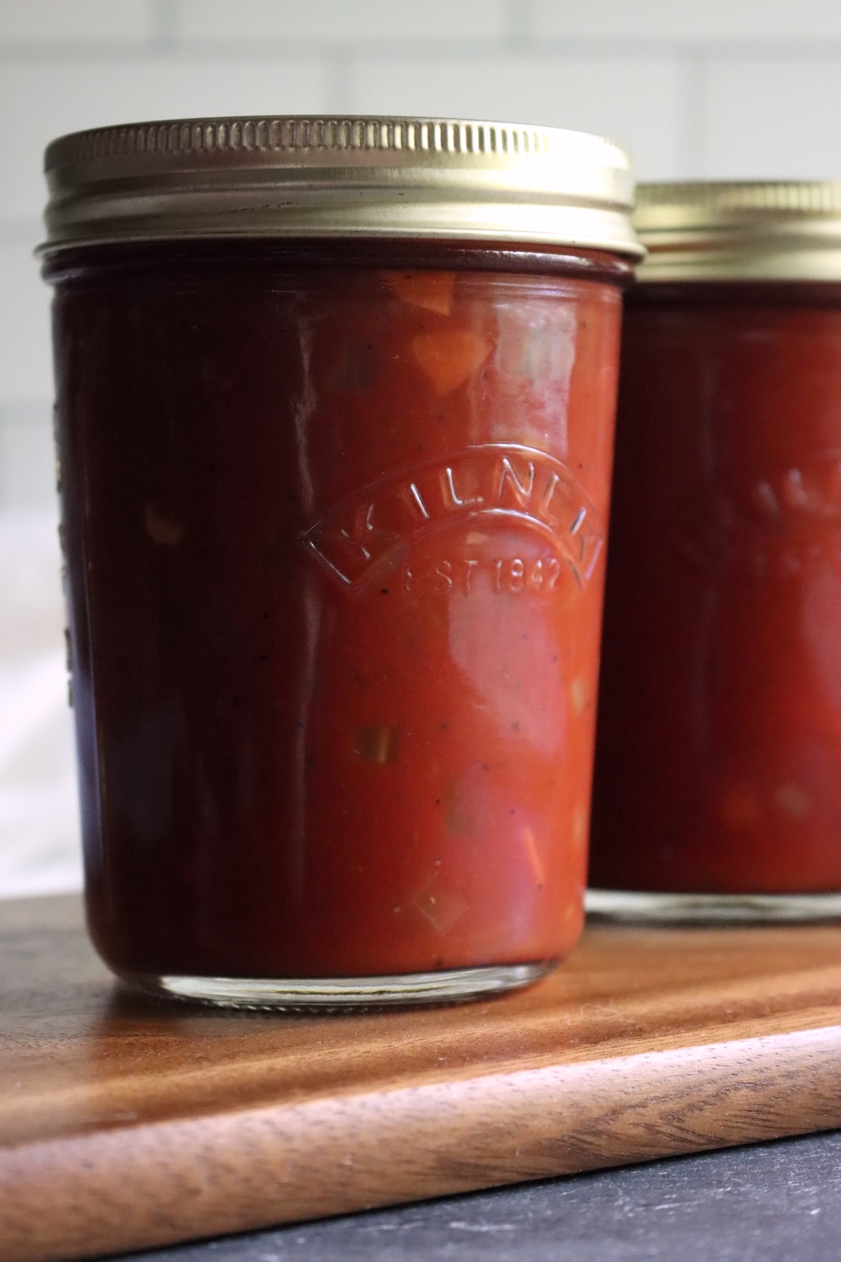 Close-up of a jar of Italian-style tomato sauce with small pieces of carrot and celery