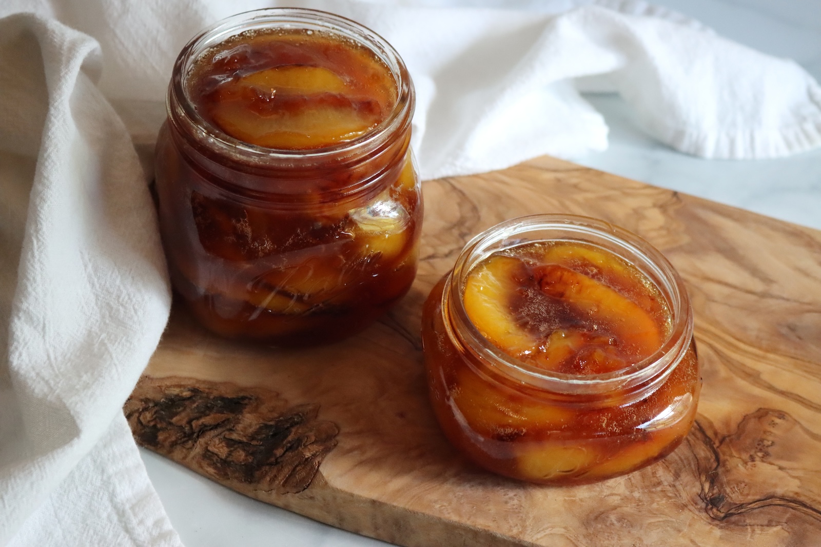 Peach preserves ladled into jars before canning.