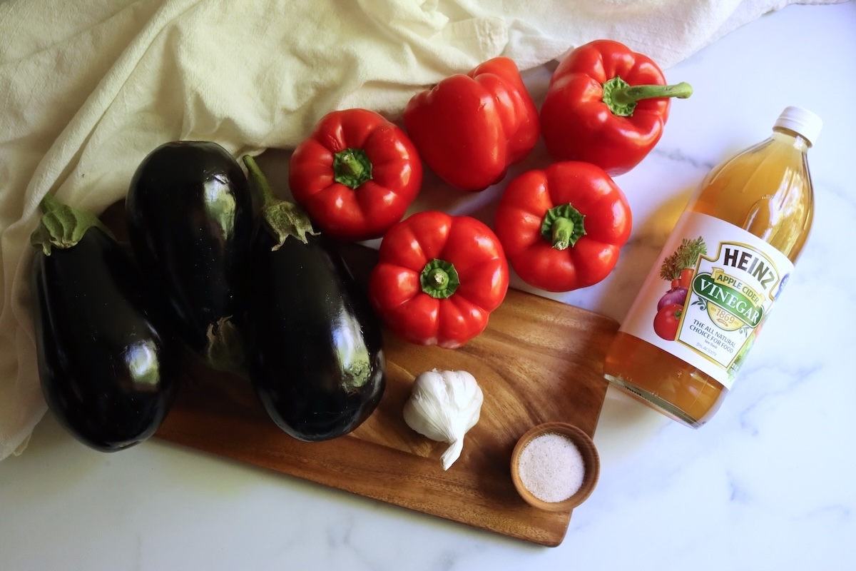 Ingredients for ajvar: eggplants, red bell peppers, a head of garlic, salt, and apple cider vinegar