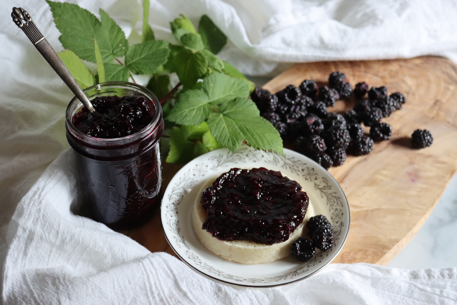 Black raspberry jam with fresh black raspberries and raspberry leaves