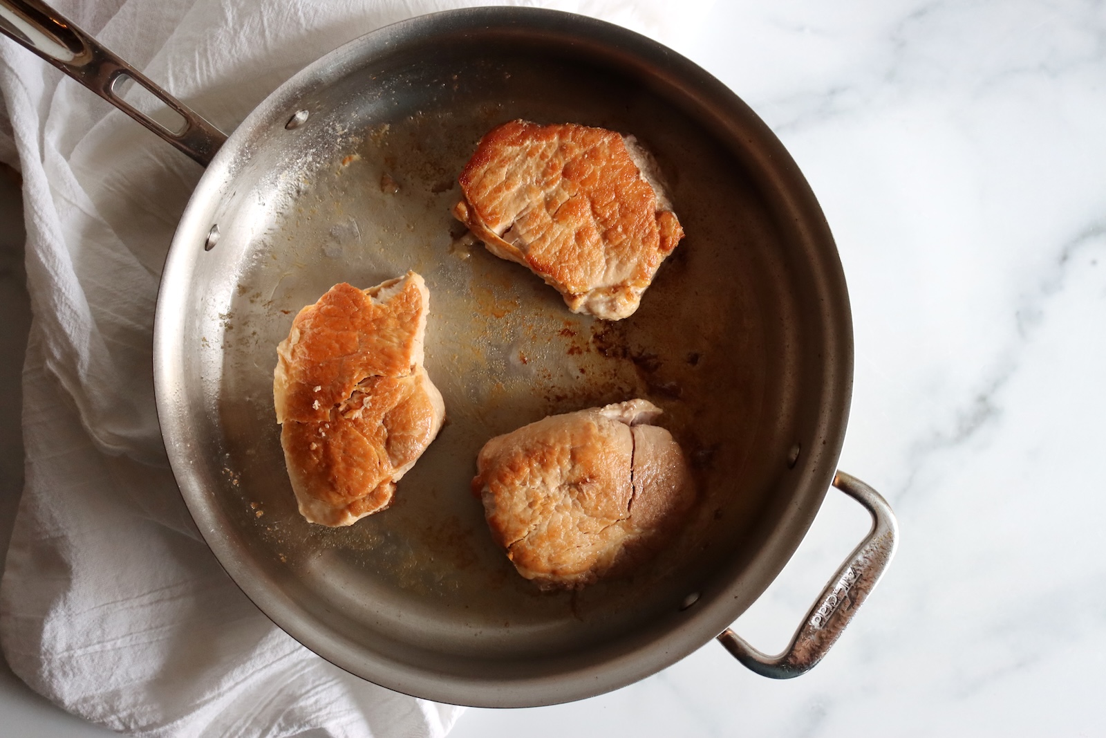 Browning canned pork chops in a skillet before serving