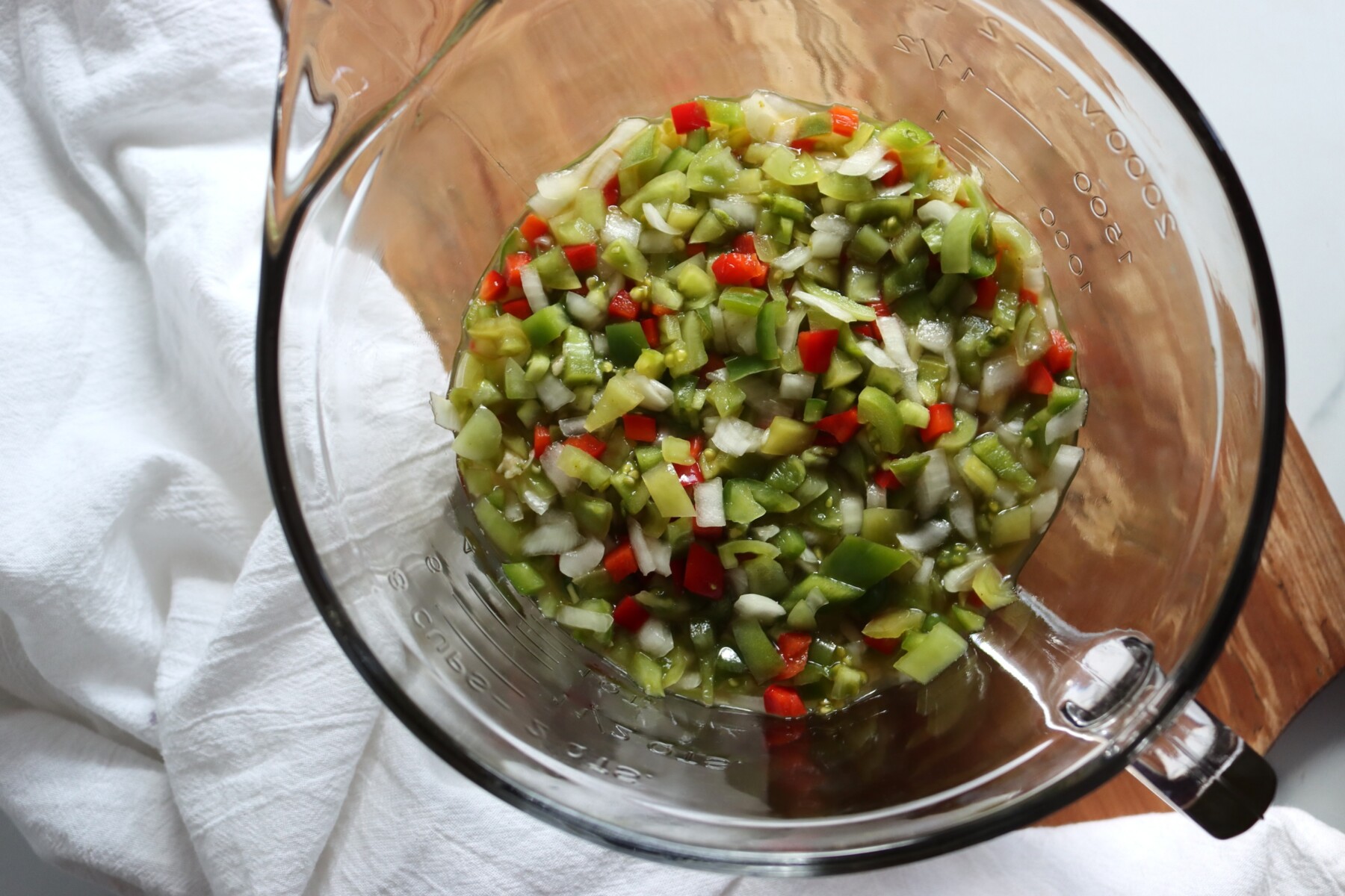 Chopped vegetables for hot dog relish in a glass bowl after an overnight salt soak