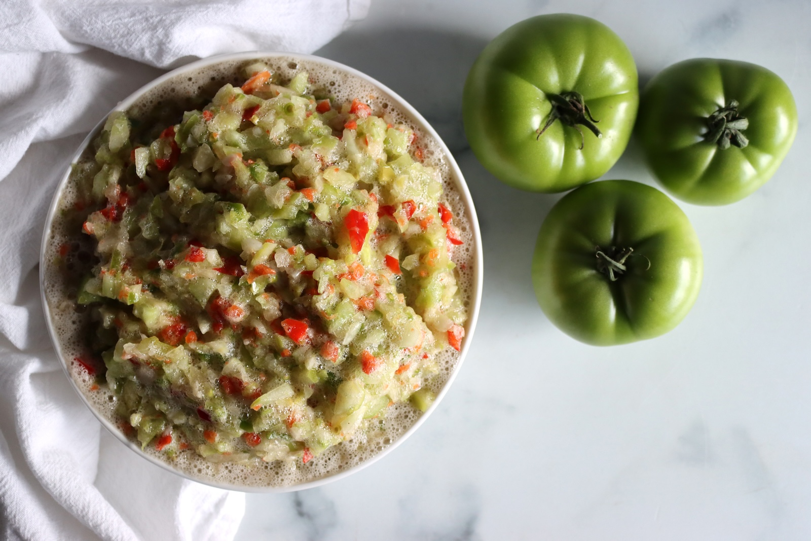 Bowl of chopped green tomatoes, bell peppers, and onions for green tomato relish