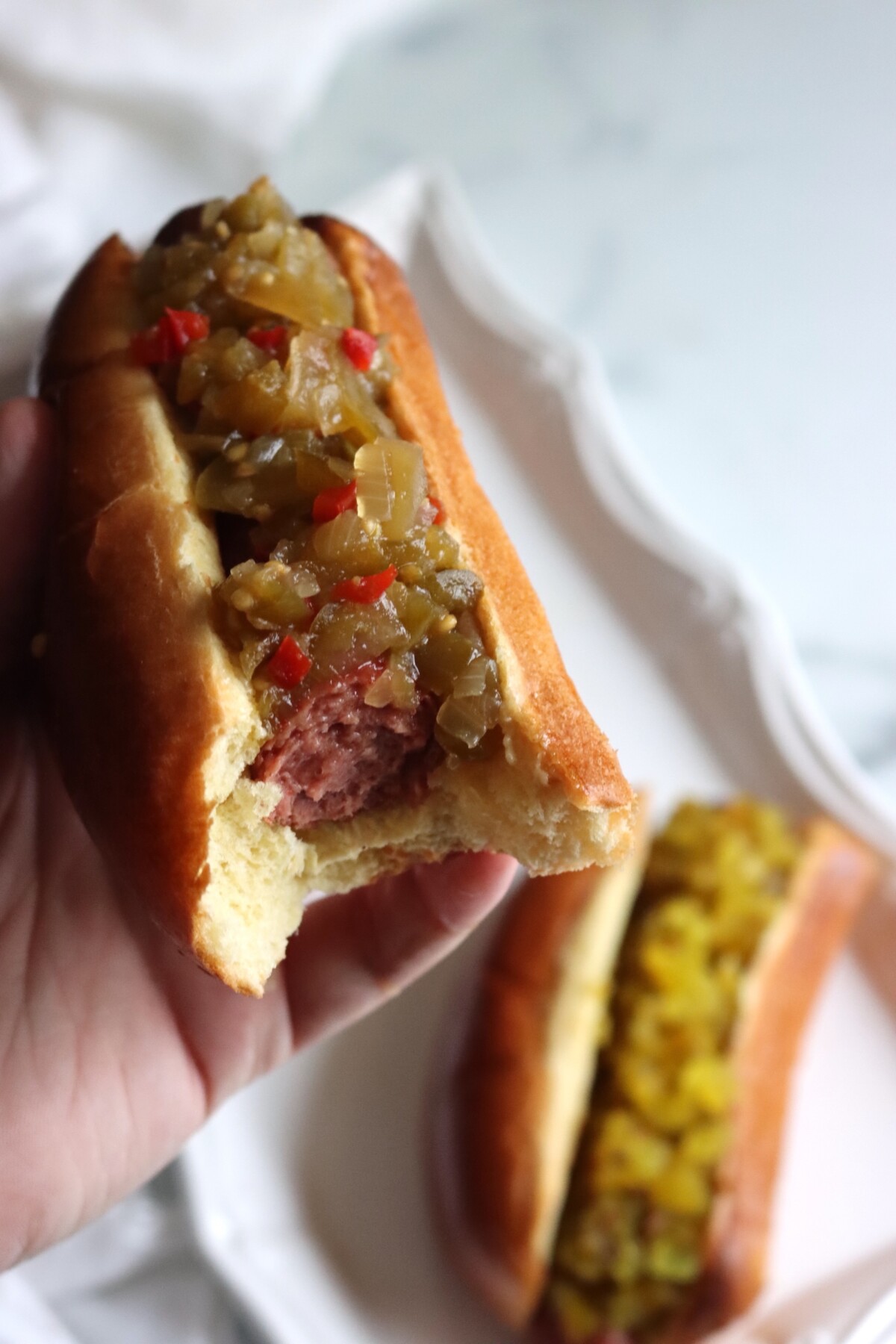 Hot dog with green tomato hot dog relish and a bite taken out