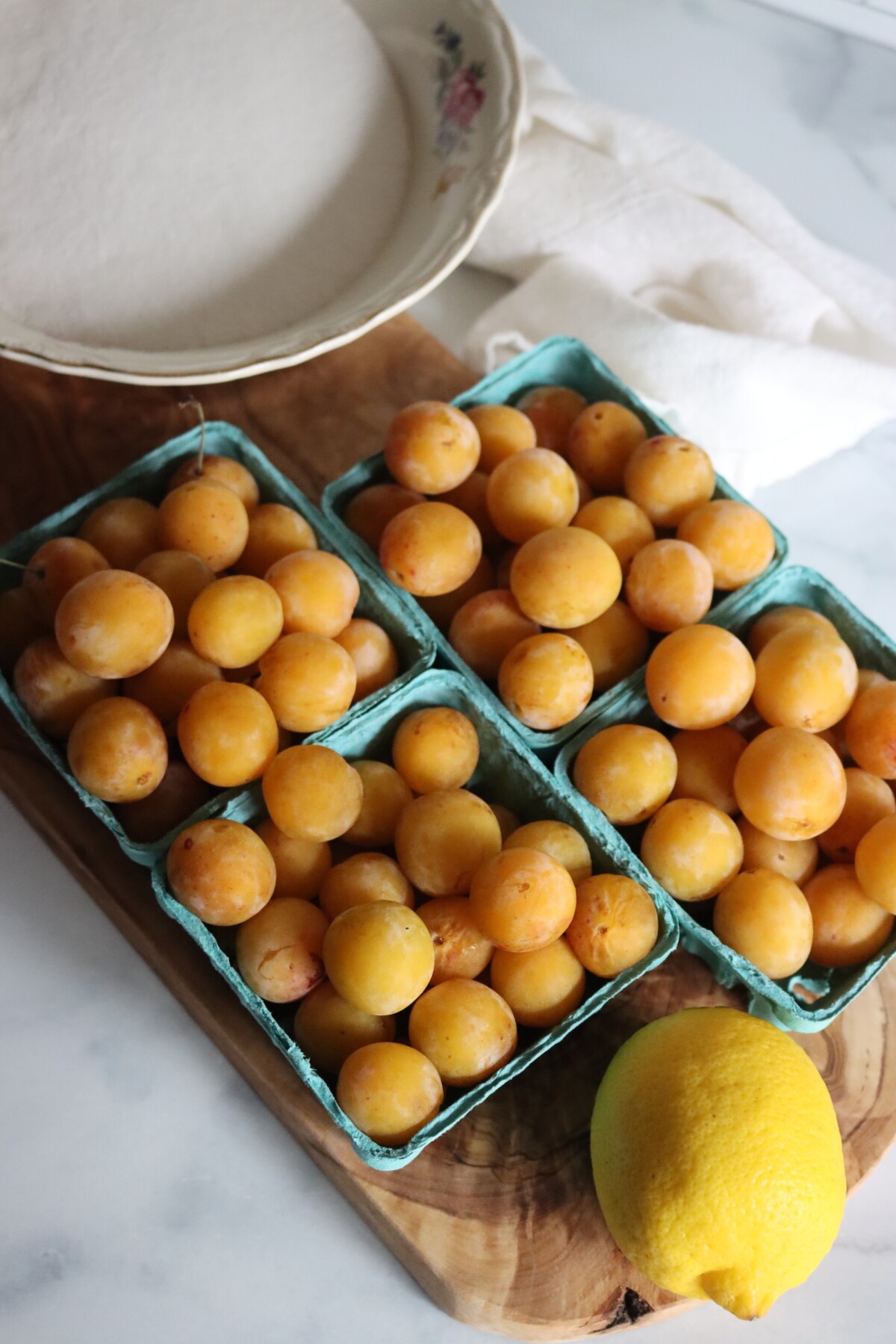 Mirabelle plum jam ingredients: fresh mirabelles, a lemon, and sugar