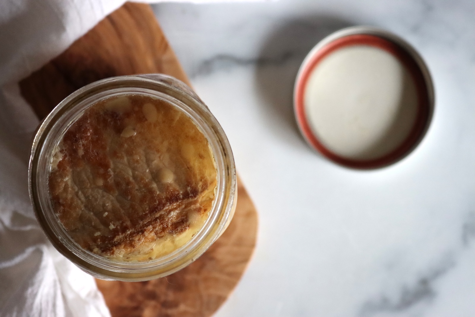 Opened jar of canned pork chops seen from above, with its lid set aside